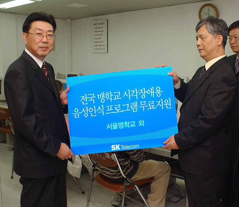 On the 7th of November, SK Telecom donated `Voice Recognition Programs for Visual Impairment (EVE)` to visually impaired youths. Young Chul Shin (left), the Head of the Promotion Department of SK Telecom, is handing a ` Voice Recognition Program for Visual Impairment` to Ki Chang Kim, the principle of the Korean School for The Blind
